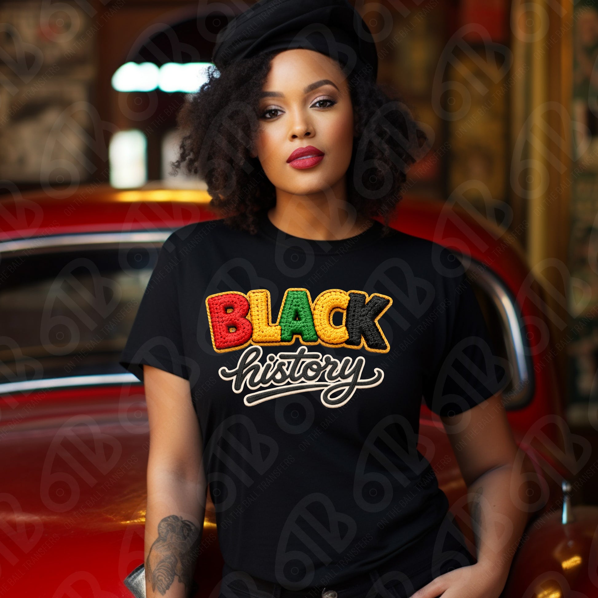 Woman wearing a black t-shirt with 'BLACK history' in colorful letters, sitting in front of a vintage car.