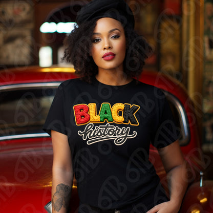Woman wearing a black t-shirt with 'BLACK history' in colorful letters, sitting in front of a vintage car.