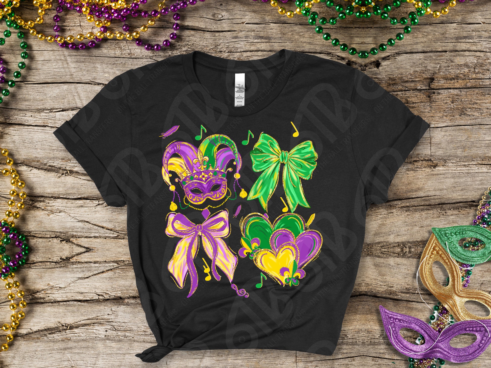 Black t-shirt with Mardi Gras-themed design on a wooden surface with festive beads and masks.