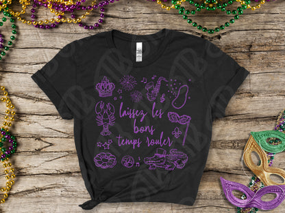 Black t-shirt with purple graphics and text on a wooden surface with Mardi Gras decorations.