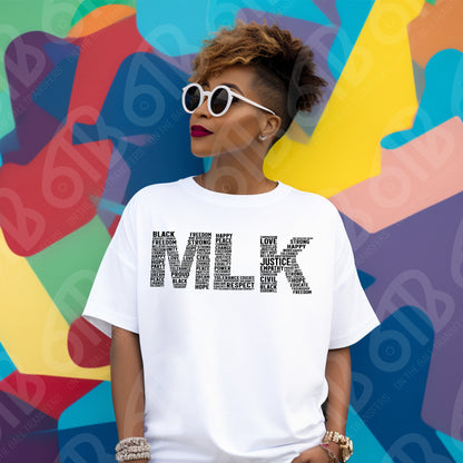 Person wearing a white t-shirt with text about Martin Luther King Jr  in front of a colorful abstract background